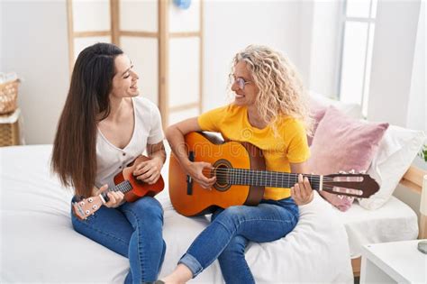 Two Women Mother And Daughter Playing Classical Guitar And Ukulele At