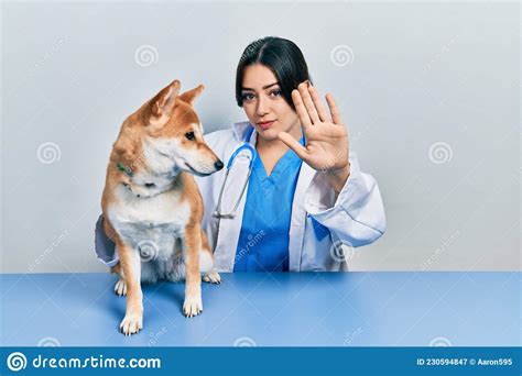 Beautiful Hispanic Veterinarian Woman Checking Dog Health With Open