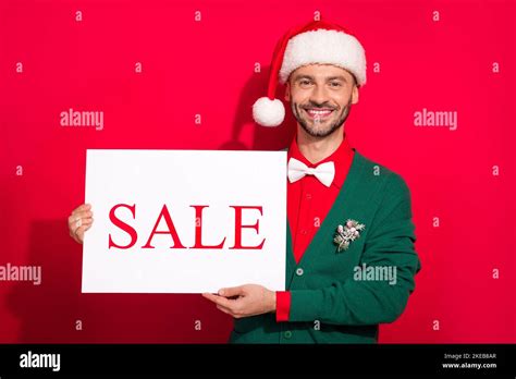 Photo Of Funky Positive Guy Dressed Xmas Green Cardigan Bowtie Showing Sale Billboard Noel Ts