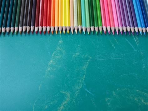 Premium Photo Color Pencils On Chalkboard Background