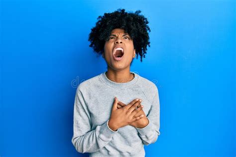 African American Woman With Afro Hair Wearing Sportswear Doing Heart Symbol With Hands Angry And