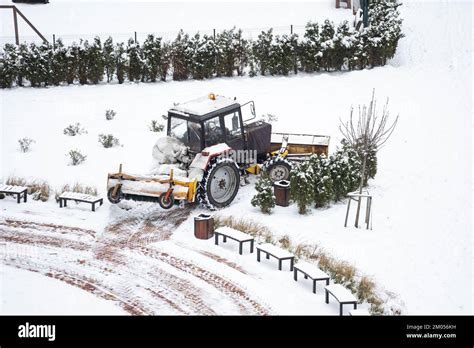 Tractor Sweep Snow With Rotating Brush And Snowplow From Pedestrian