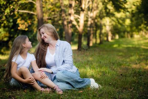 Mother And Daughter Lying On A Grass Outdoors And Smiling Stock Image