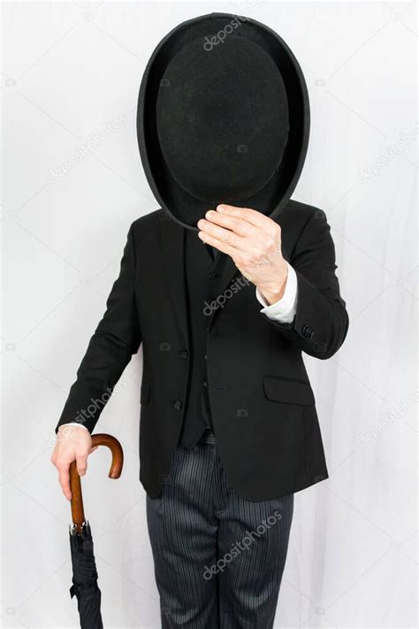 Portrait Of Man In Dark Suit Tipping Bowler Hat Politely On White