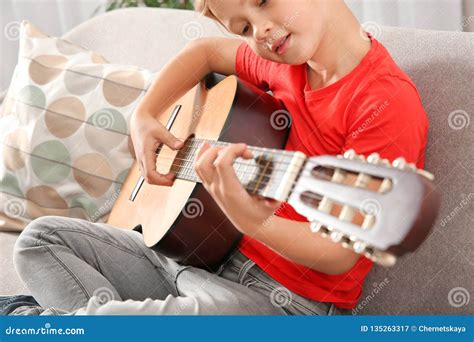 Netter Kleiner Junge Der Gitarre Auf Sofa Spielt Stockbild Bild Von Zicklein Kunst 135263317