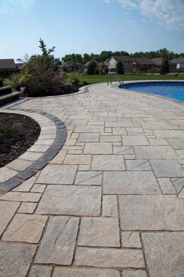 A Stone Walkway Next To A Swimming Pool