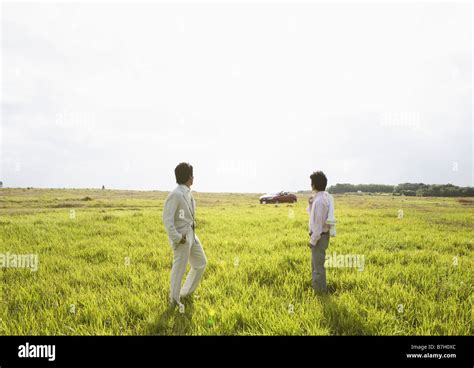 Two Men In A Field Of Grass Stock Photo Alamy