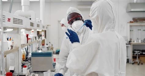 Premium Photo Medicine Scientists Wearing Ppe Pouring Liquid In Test