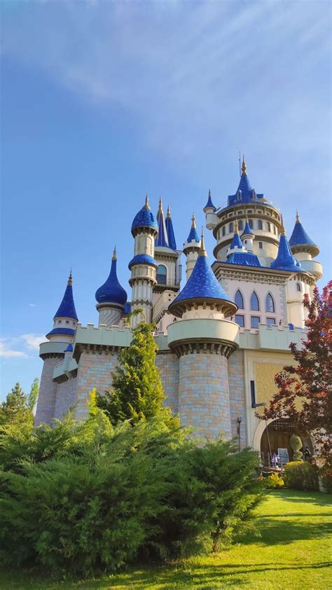 A Large Castle With Blue Domes On It S Sides And Trees In The Foreground