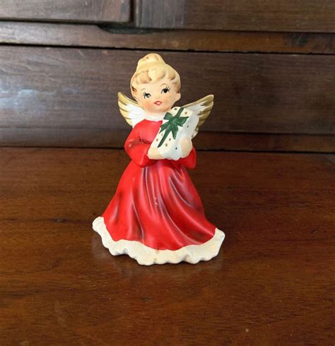 A Little Angel Figurine Sitting On Top Of A Wooden Table