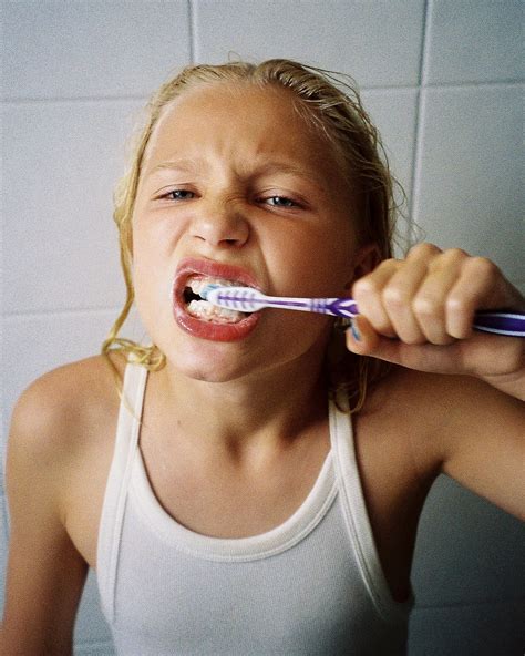 Analogt porträttfotografi som föreställer en tjej som borstar tänderna