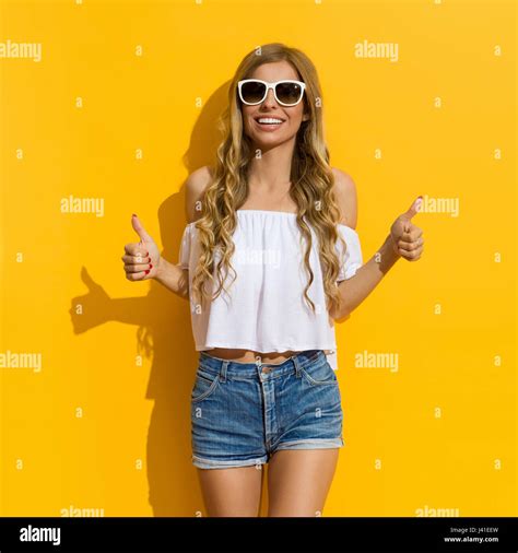 Smiling Blond Young Woman In Jeans Shorts White Shirt And Sunglasses