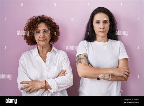 Hispanic Mother And Daughter Wearing Casual White T Shirt Over Pink Background Skeptic And