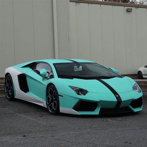 A Blue And White Sports Car Parked In Front Of A Building