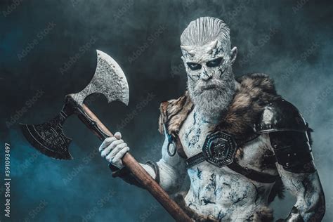 Armed With Two Handed Axe Northern Dead Warrior With Naked Torso And Pale Skin Poses In Dark