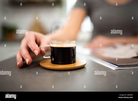 Closeup Of Woman Reading Magazine Whilst Drinking Coffee Stock Photo