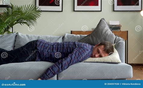 Exhausted Young Man Falling Asleep On Couch Feeling No Energy After