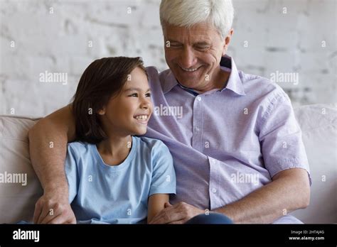 Mature Grandfather His Lovely Grandson Smiling Hugging Sit On Sofa