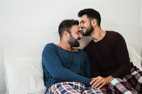 Jeune couple gay ayant un moment tendre au lit à la maison Focus sur les visages Photo Premium