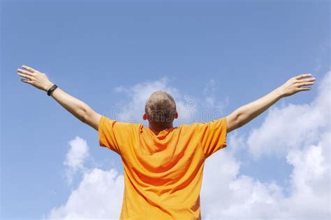 The Guy Stands With His Arms Outstretched To The Sky Stock Photo