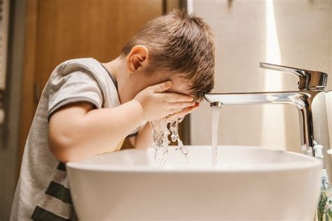 Un niño en el baño se lava la cara Foto Premium