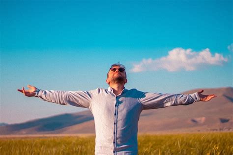 Premium Photo A Man With His Arms Outstretched In Front Of A Field Of