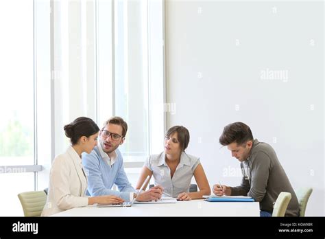 Business People Meeting Around Table In Modern Space Stock Photo Alamy