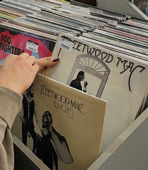 A Person Looking At Records In A Record Store With Their Hands On The