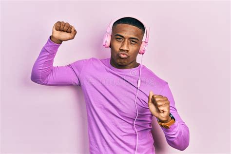 Young Black Man Dancing Listening To Music Using Headphones Looking At