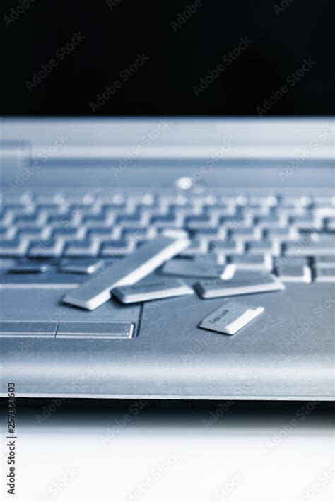 Silver laptop with broken keyboard. A close-up picture of part of ...