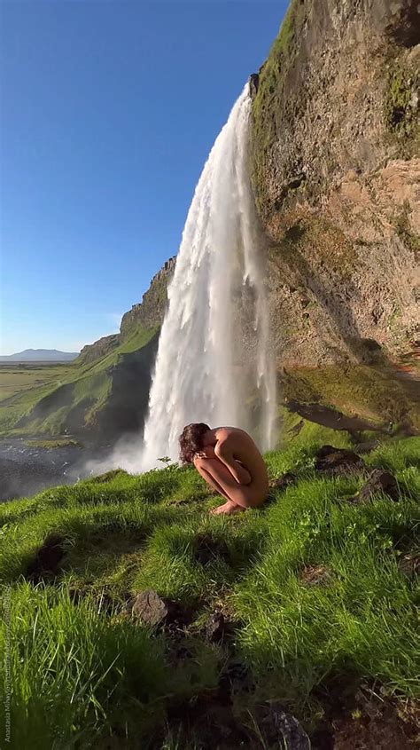 Nude Woman Sitting On The Green Grass By The Waterfall In Iceland By Stocksy Contributor