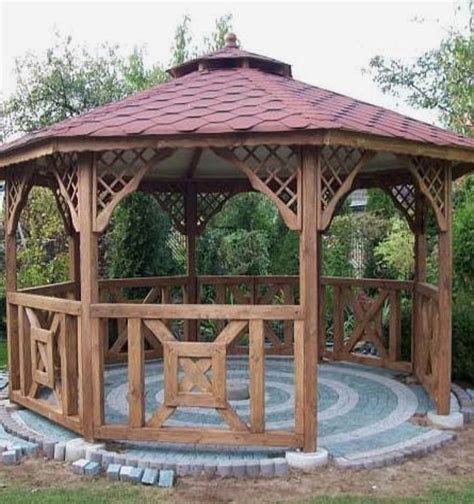 A Wooden Gazebo Sitting On Top Of A Lush Green Field