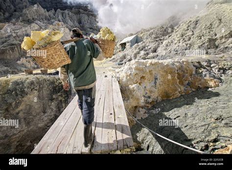 Miner Carrying Baskets With Sulfur Inside The Crater Of Ijen Volcano