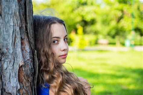 Premium Photo Girl Long Curly Hair Lean On Tree Trunk United With