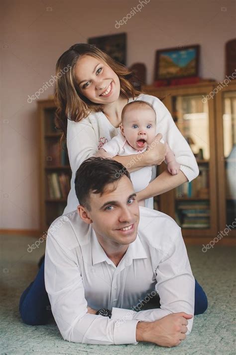 Familia joven y feliz con un niño pequeño en sus brazos fotografía