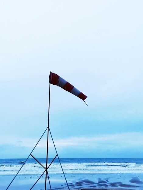 Premium Photo Flag On Beach Against Sky