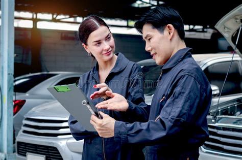 Happy Mechanic Man And Woman Mechanic In Uniform Discussing While