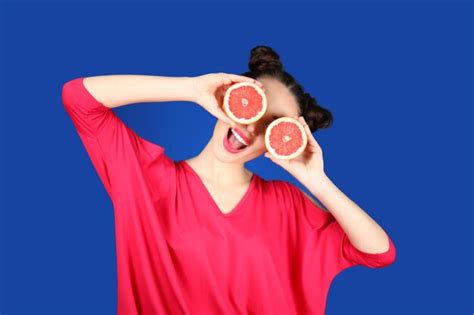 Hermosa Mujer Joven Con Mitades De Pomelo Cerca De Los Ojos Sobre Fondo