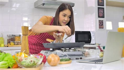 Young Asian woman cooking in kitchen at home. 11273555 Stock Photo at Vecteezy