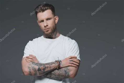 Retrato De Joven Guapo Tatuado En Camiseta Blanca De Pie Con Los Brazos