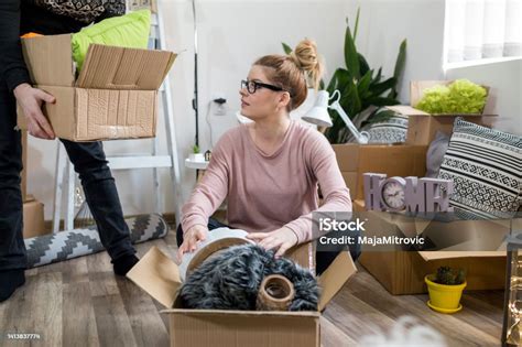 Young Couple Carrying Big Cardboard Box At New Home Moving House Stock