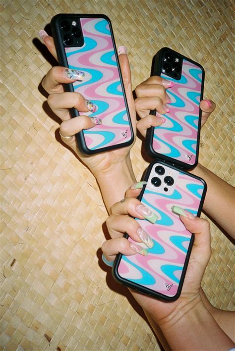 Two Women Holding Up Their Cell Phones With Different Designs On The