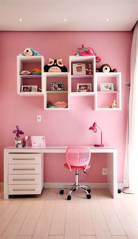 A Room With Pink Walls And White Shelves On The Wall Along With A Desk