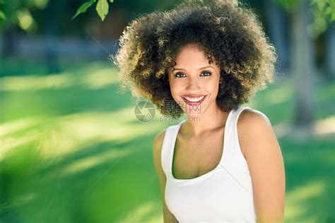 轻的黑人妇女留着afro发型城市公园微笑穿着休闲衣服的混合女孩高清图片下载 正版图片300083696 摄图网