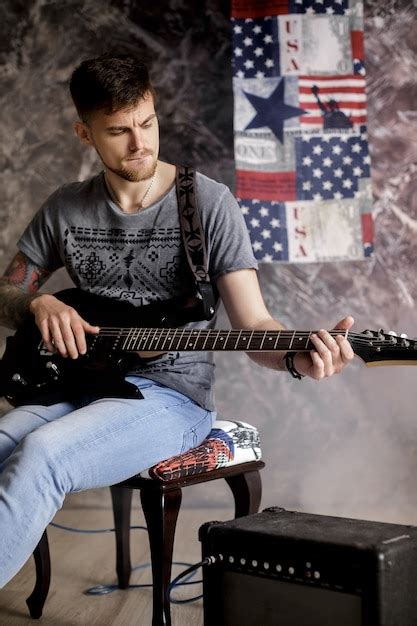 Joven Guapo M Sico Tocando La Guitarra El Ctrica Sobre Un Fondo Oscuro