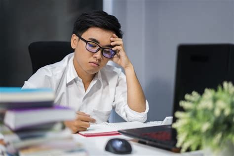 Premium Photo Stressed Man Studying With Book And Laptop