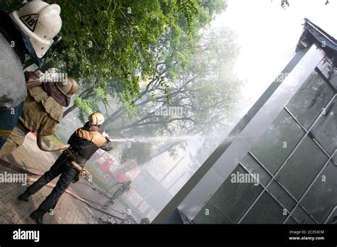 Fireman Spraying Water Firefighters Extinguish A Fire In An Apartment