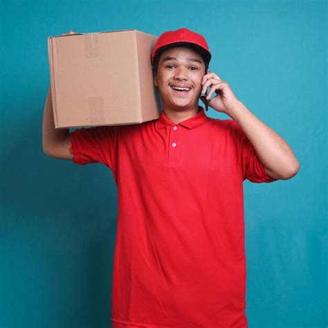 Jovem Entregador De Camisa Vermelha Carregando Caixa E Segurando O