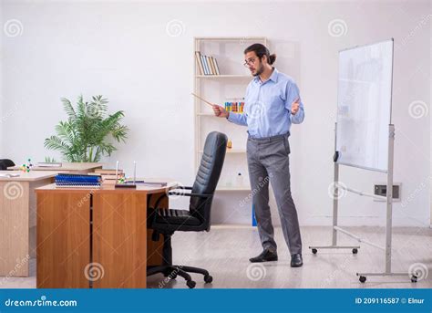 Young Male Teacher In Front Of Whiteboard In The Classroom Stock Image