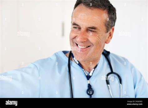 An Experienced Mature Doctor Smiling Against White Closeup Portrait